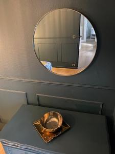 - un miroir au-dessus d'une table dans l'établissement Appartement cosy en centre ville avec SPA et jardin, à Dijon