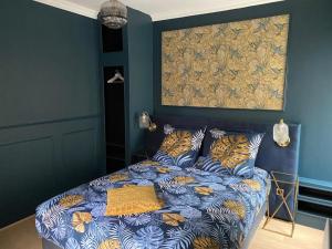 Ce lit se trouve dans un dortoir doté d'un mur bleu. dans l'établissement Appartement cosy en centre ville avec SPA et jardin, à Dijon