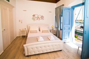 a bedroom with a white bed and a balcony at spongkalyA apartment I in Kalymnos
