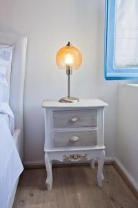 a lamp on a white night stand next to a bed at spongkalyA apartment I in Kalymnos