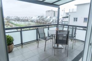 a balcony with chairs and a table on a balcony at City Wohnung Relax 3 klimatisiert in Friedrichshafen
