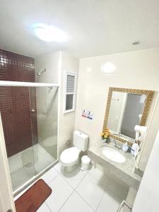 a bathroom with a toilet and a shower and a sink at Arraial do Cabo - Condomínio com cara de Resort in Arraial do Cabo