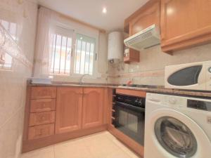 a kitchen with a washing machine and a microwave at AyF BAHIA 1ª LINEA DE PLAYA WIFI INCLUIDO in Oropesa del Mar