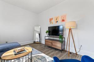 un soggiorno con divano blu e TV di Casa Soleada in East Rock near DT and Yale SOM with FREE Parking and King Bed a New Haven