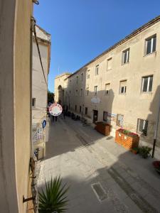 een lege straat in een steeg tussen twee gebouwen bij Lu Bàtil B&B - Rooms in Alghero