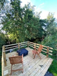 Countryside Cabin في تونتون: كرسيين وحقيبة زرقاء جالسة على سطح خشبي