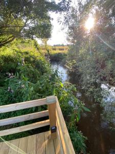 a bench sitting on a bridge over a river at Countryside Cabin in Taunton