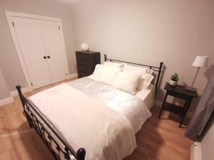 ein Schlafzimmer mit einem großen Bett mit weißer Bettwäsche und Kissen in der Unterkunft Modern 1 bedroom apartment in Wortley Village in London