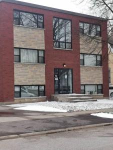 a red brick building with snow in front of it at Modern 1 bedroom apartment in Wortley Village in London