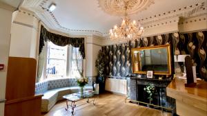 a living room with a television and a chandelier at Whites Hotel in Newcastle upon Tyne