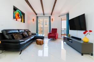 a living room with a black leather couch and a flat screen tv at Apartamento Torrevieja Sunrise Atalayas in Torrevieja