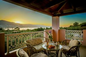 a balcony with a table and chairs and a sunset at Mirimar Apartments in Alikanas