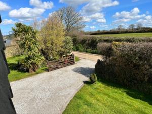 a wooden gate in a garden with a field at Croft View in Helston