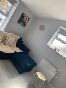 sala de estar con sofá azul y ventana en The Honeycomb, en Ballyshannon
