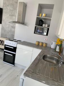 a white kitchen with a sink and a stove at The Honeycomb in Ballyshannon