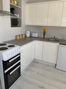 a kitchen with white cabinets and a stove top oven at The Honeycomb in Ballyshannon