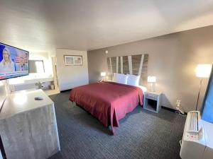 Cette chambre comprend un lit et une télévision à écran plat. dans l'établissement Excellent Inn & Suites, à Natchez