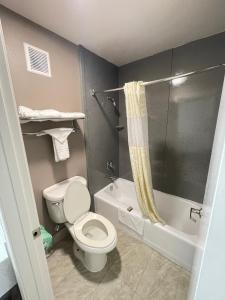 a small bathroom with a toilet and a shower at Excellent Inn & Suites in Natchez