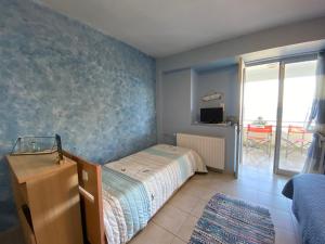 um quarto com uma cama e uma parede azul em Evita Studios em Xiropigado