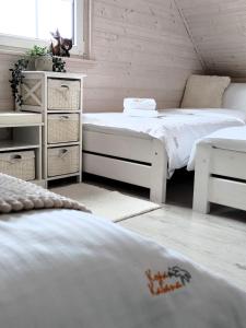 een slaapkamer met 2 bedden en een dressoir. bij Kopań Kabana in Darłowo