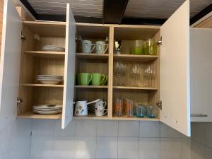 un armario lleno de tazas, platos y vasos en Lili, en Brežice