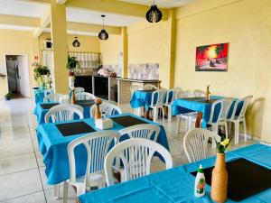 ein Restaurant mit blauen Tischen und weißen Stühlen in der Unterkunft Hotel Ondas do Mar in Salinópolis