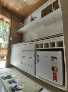 uma cozinha com um frigorífico branco num quarto em Chalés Schwambach em Domingos Martins