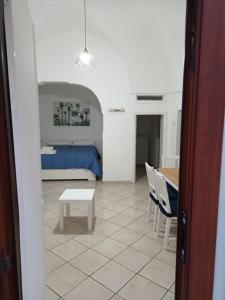 a room with a bed and a table and chairs at Vico Trieste in Ostuni