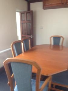 a dining room table with chairs and a wooden table at Honeycomb Cottage in Aberdare