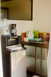 a kitchen with a counter with a microwave and a refrigerator at Corcovado Green Cabin in Drake