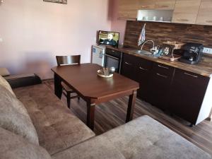 a kitchen with a wooden table and a kitchen with a sink at Guest Room Descreet in Pavel Banya