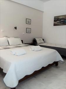 a bedroom with a large white bed with white sheets at Areti & Maria Apartments in Gythio