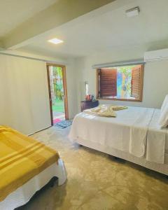 Un dormitorio con dos camas y una ventana. en Pousada Jaboticaba Caraíva, en Caraíva 17 fotos más