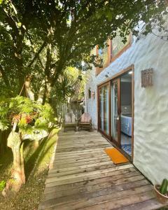 a wooden pathway leading to a house with a tree at Pousada Jaboticaba Caraíva in Caraíva