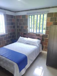 a bedroom with two beds and a brick wall at Club Recreativo Las Guitarras in Florián