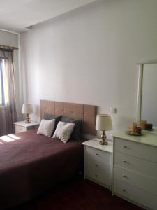 ナザレにあるNazaré - Avenida Vieira Guimarãesのベッドルーム1室(ベッド1台、ナイトスタンド2台、ランプ2つ付)