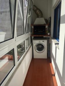 ナザレにあるNazaré - Avenida Vieira Guimarãesの窓付きの客室で、洗濯機が備わります。
