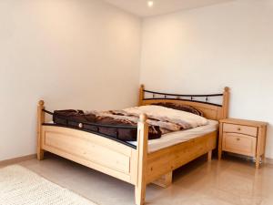 a bedroom with a wooden bed and a night stand at Big Apartment with garden Rapperswil-Jona in Jona