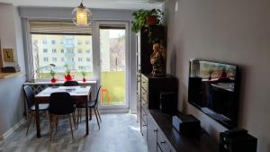 a living room with a dining room table and a television at Apartament z widokiem na las in Sopot