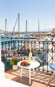 a table with fruit on a balcony with a harbor at spongkalyA apartment II in Kalymnos