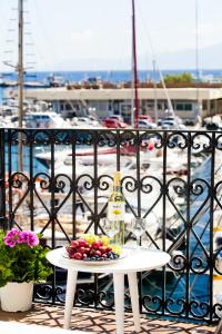 einen Tisch mit einer Flasche Wein und Obst auf dem Balkon in der Unterkunft spongkalyA apartment II in Kalymnos