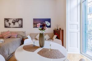 sala de estar con mesa y jarrón con flores en Museum Luxury Suites, en Nápoles