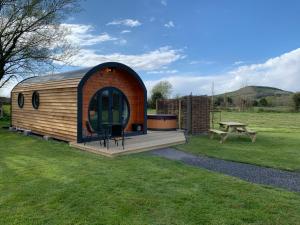 a wooden cabin in a field with a picnic table at Laurel Farm Glamping in Mark