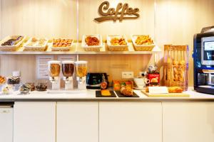 a counter with some food and drinks on it at BRIT Hotel Rouen Nord - Barentin in Barentin