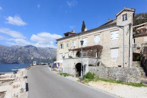 an old stone building on the side of a road at Kazerma Apartment in Perast