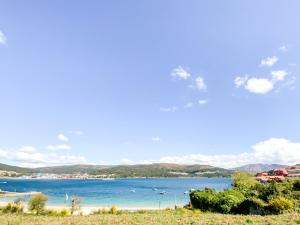 a view of a beach with mountains in the background at Apartamento Fufú by ALÔGA in Corcubión