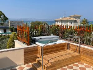 a hot tub sitting on top of a deck at Lake Front Apartment - Direct Lake Access in Sirmione