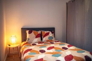 a bed with a colorful comforter in a bedroom at Vernon, Le Pacia in Vernon