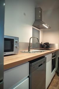 a kitchen with a sink and a microwave at Vernon, Le Pacia in Vernon