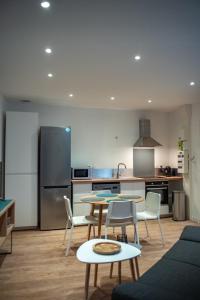 a kitchen with a table and chairs and a refrigerator at Vernon, Le Pacia in Vernon